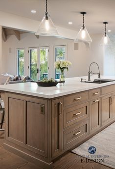 a large kitchen with an island in the middle and lots of lights hanging from the ceiling