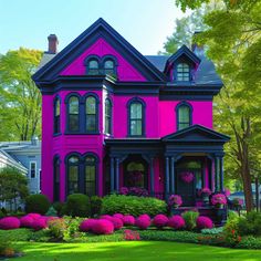 a pink and black house with lots of flowers in front of it on a sunny day