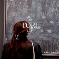 a woman standing in front of a painting with the words tori bird on it