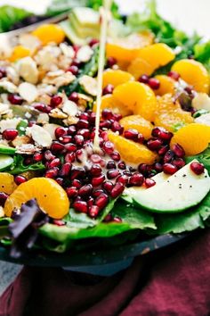 a salad with oranges, avocado and pomegranate on it