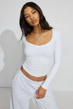 This and some sweats >>> Features - V neck - Long sleeves - Very stretchy Size & Fit - Fit: Fitted - Length: Cropped - Model is wearing size S Materials & Care - Content: 60% nylon, 20% recycled nylon, 20% spandex - Care: Machine wash, cold - Imported White Long Sleeve Top Outfit, White Long Sleeve Outfit, White Tops Outfit, Long Sleeve Shirt Outfits, Garage Clothing, Long Sleeve Outfits, White Long Sleeve Top, White Long Sleeve Shirt, Autumn Clothes