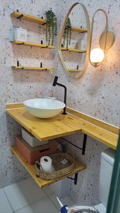 a bathroom with a sink, toilet and shelves on the wall next to each other