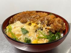 a red bowl filled with food on top of a table