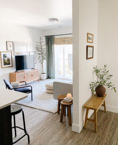 a living room filled with furniture and a flat screen tv sitting on top of a wooden table