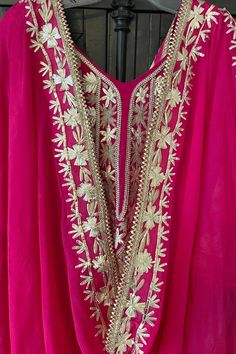 This beautifully designed Hot Pink Hand Embroidered Silk Anarkali Dress is crafted with intricate Tilla and Gotta work, creating a stunning choice for any special event. This dress includes a matching silk churidar bottom and a 2.5 meter pure chinon silk embroidered dupatta chunni, perfect for weddings and parties. Silk Chinon Silk Dupatta 2.5 meter Lined Hand Embroidered String tie back with zipper Churidar bottom Full elastic waist band Work: Handcrafted gotta work, tilla work Condition: New O Pink Chanderi Dress With Intricate Embroidery, Traditional Drape Kaftan With Gota Work For Parties, Party Kaftan With Gota Work And Traditional Drape, Festive Party Kaftan With Gota Work, Wedding Chanderi Kaftan With Mirror Work, Traditional Mirror Work Kaftan For Party, Festive Anarkali Kaftan With Mirror Work, Anarkali Style Gota Work Kaftan For Festive Occasions, Bollywood Style Kaftan With Gota Work For Party