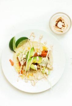 a white plate topped with food next to a cup