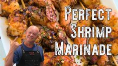 a man standing in front of a plate of chicken skewers with the words perfect shrimp marinade on it