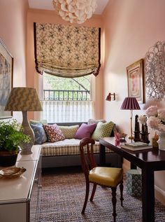 a living room filled with furniture and flowers on top of a window sill next to a table