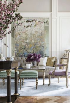 a living room filled with lots of furniture and flowers in vases on top of tables