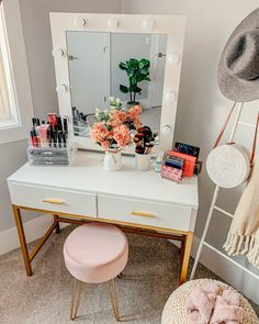 a white vanity with flowers and makeup on it