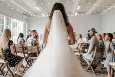 the back of a bride's dress as she walks down the aisle