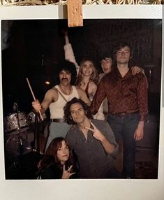 a group of people posing for a photo with drumsticks in front of them