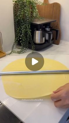 a video demonstrating how to use an oven mitt on a counter top with plants in the background