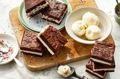 several pieces of cake on a cutting board with ice cream and sprinkles