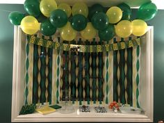 a birthday party with balloons and streamers on the window sill in front of it