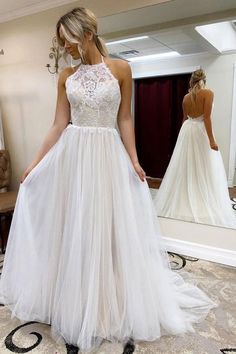 a woman is standing in front of a mirror wearing a wedding dress