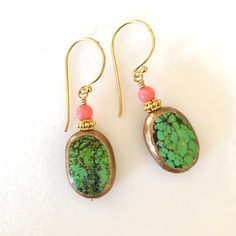 "Beautiful genuine green turquoise gemstones edged in golden copper with pale orange coral accent on 24k gold vermeil ear hooks. Artisan lime green turquoise gemstones are natural 17 x 12 x 6mm oval stones edged in golden copper. Each side has unique matrix patterns giving it a lovely rustic appearance. 4mm natural coral rounds in pale orange add pop of color. Accented with 24k gold vermeil spacer beads. Lightweight earrings hang from 24k gold vermeil artisan ear wires. Total length is 1 1/2\"." Gold Bohemian Jewelry With Malachite, Gold Bohemian Malachite Jewelry, Turquoise Oval Earrings With Natural Stones, Oval Green Brass Jewelry, Green Brass Earrings With Natural Stones, Handmade Turquoise Fusion Earrings, One Of A Kind Turquoise Brass Jewelry, Handmade Oval Turquoise Earrings, Green Gemstone Copper Jewelry