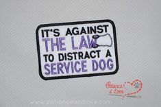 it's against the law to distract a service dog embroidered patch on white shirt