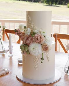 a white wedding cake with flowers on it