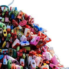 a pile of different colored plastic objects on display in a market place with white sky background