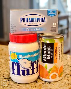 an open can of yogurt next to a container of fluff on a counter