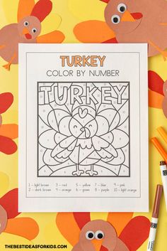 the turkey color by number is on top of a table with markers and crayons