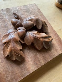 a wooden cutting board with carved leaves on it