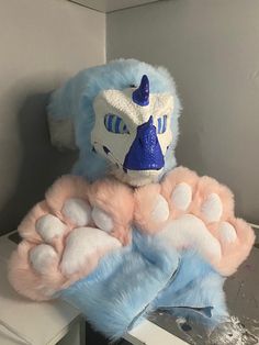 a blue and pink stuffed animal on top of a table