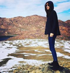 a woman standing on top of a snow covered mountain