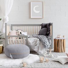 a baby crib in a white room with plants and other items on the floor