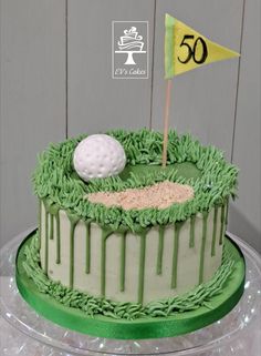 a birthday cake decorated with green icing and a golf ball on the top of it