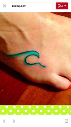 a woman's foot with a wave tattoo on her left foot and polka dot dots in the background