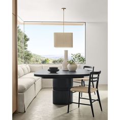 a black table with two chairs and a lamp in the middle is next to a white couch