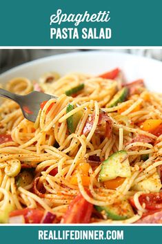 spaghetti with zucchini and tomatoes in a white bowl