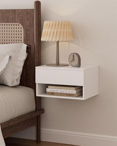 a nightstand with a lamp on top of it next to a bed