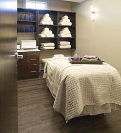 a massage room with towels on the shelves