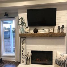 a living room with white brick fireplace and large screen tv