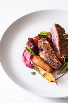 a white plate topped with meat and veggies