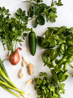 green vegetables are laid out on a white surface