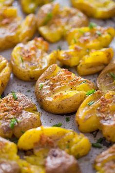 baked potatoes with herbs and seasoning sitting on a baking sheet