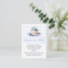 a blue and white card with a cake on it next to a vase filled with flowers