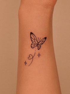 a small butterfly tattoo on the wrist and arm, with stars in the foreground