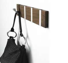 a purse hanging on the wall next to a pair of scissors and a hook that is attached to it