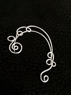 14kt Gold Filled or sterling silver, Swirl Vine Ear Cuff Wrap is awesome! It is a vine from the top to the bottom of the ear with leaves and swirls. It is held on with a clip to the back of the ear. The ear cuff will fit best on ears just a bit over 2 inches. You will receive one ear-cuff that can be worn on the LEFT EAR. if you would like it for the right side please leave a note in check out I have a more fun items here http://www.etsy.com/shop/wickedlywired?ref=si_shop Elegant Silver Spiral Ear Cuff, Unique Silver Wire Wrapped Ear Climbers, Elegant Spiral Ear Cuff, Elegant Spiral Single Ear Cuff, Elegant Spiral Shaped Single Ear Cuff, Handmade Silver Ear Climbers, Ear Decoration, Pierced Ear, Ear Climber