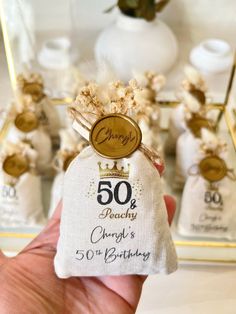 someone is holding up a small bag with the number 50 and it's 50th birthday