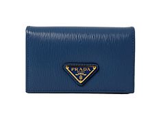 This vibrant blue Prada card holder is an effortlessly chic way to store credit cards, business cards, coins, and small objects. The wallet's conveniently small size makes it easy to keep in your purse or pocket. Three card slots and a main pocket mean organizing is a breeze.     Model: 1MC122  Cobalto blue leather  Gold-tone hardware  Snap closure  Card holder/wallet  Signature Prada Triangle logo   Measurements: 4.5" x 1.5" x 2.5" (LWH)  Includes authenticity cards and Prada box   Made in Ital Designer Compact Wallets With Card Slots, Designer Compact Wallet With Card Slots, Designer Compact Card Holder With Card Slots, Designer Blue Bags With Card Slots, Blue Designer Bags With Card Slots, Formal Blue Bags With Card Slots, Modern Rectangular Card Holder With Logo Plaque, Modern Wallets With Logo Plaque For Everyday, Elegant Blue Coin Purse With Card Slots