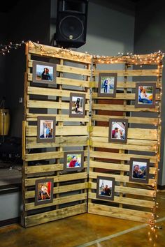 an open wooden box with pictures on it and string lights hanging from the ceiling above