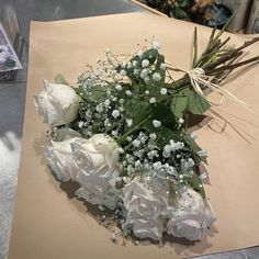 a bouquet of white roses sitting on top of a piece of paper