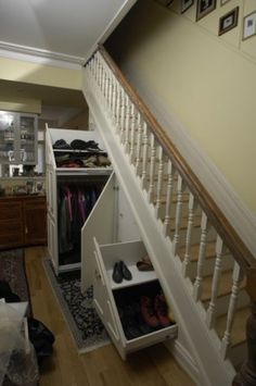 an open closet under the stairs in a house with shoes and other items on it