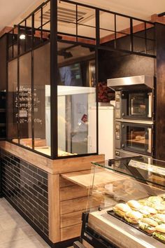 a bakery with lots of food on display in the counter and behind it is a glass case